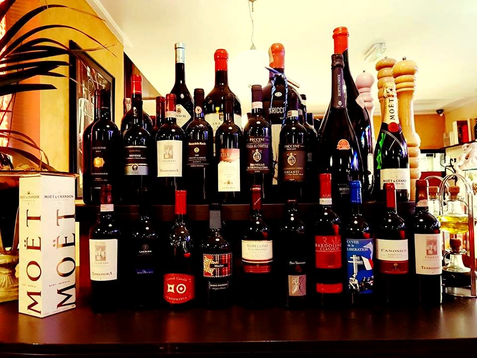 The wine bar at Tuscany Too, bottles glowing in warm light